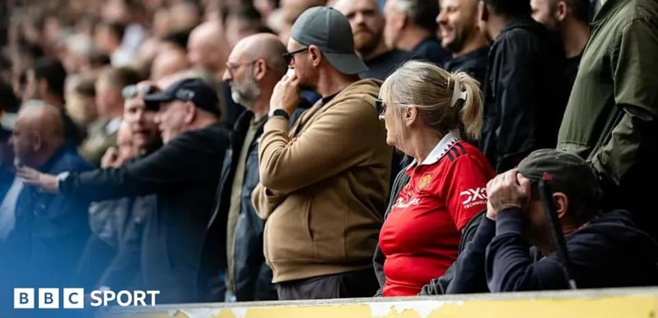 Fans watching the match in the stadium stands