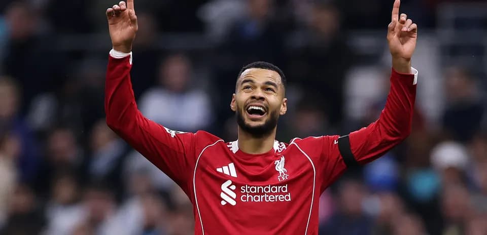 Player celebrating with arms raised in Liverpool kit