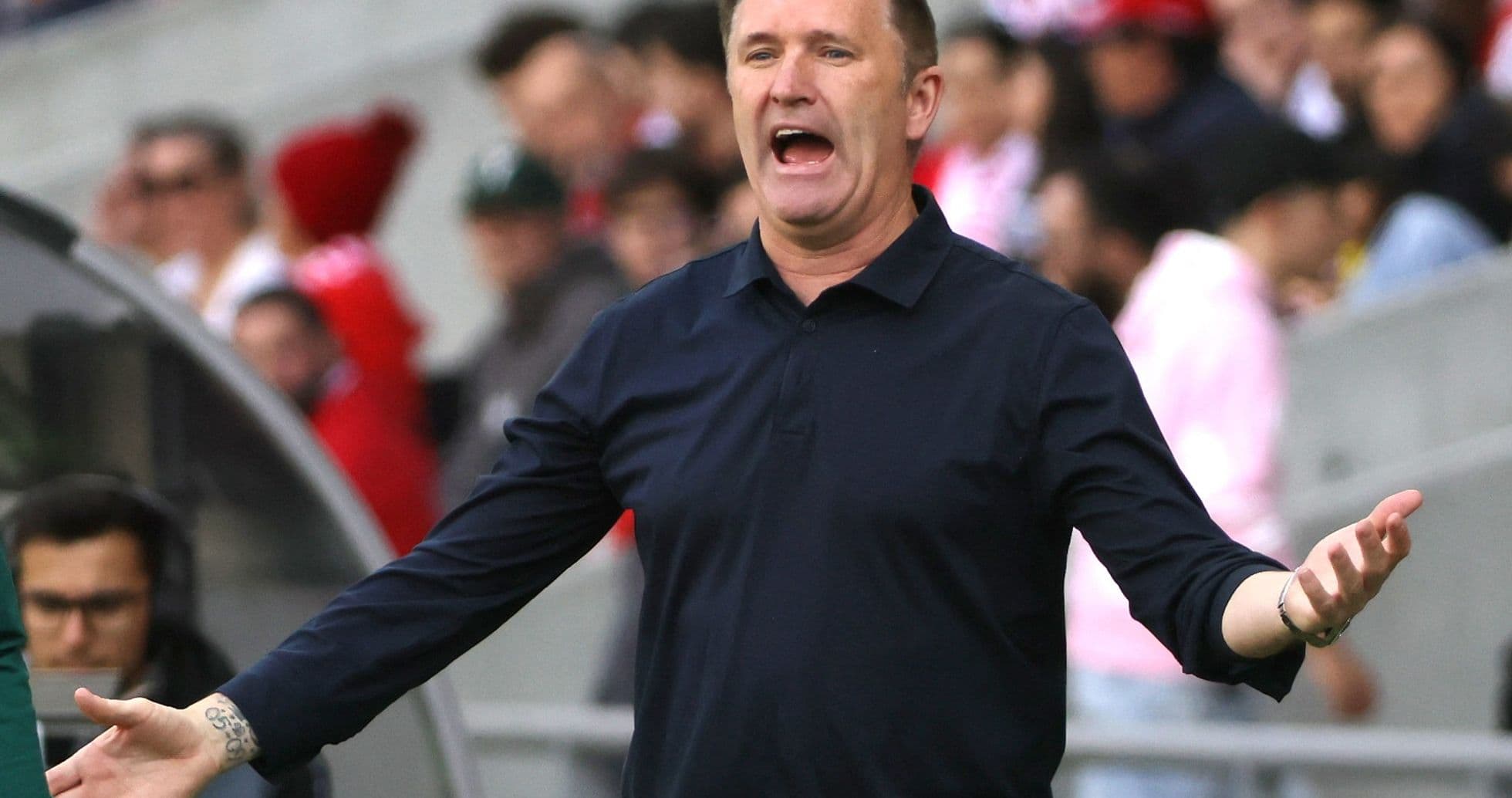 Coach gesturing passionately during a match