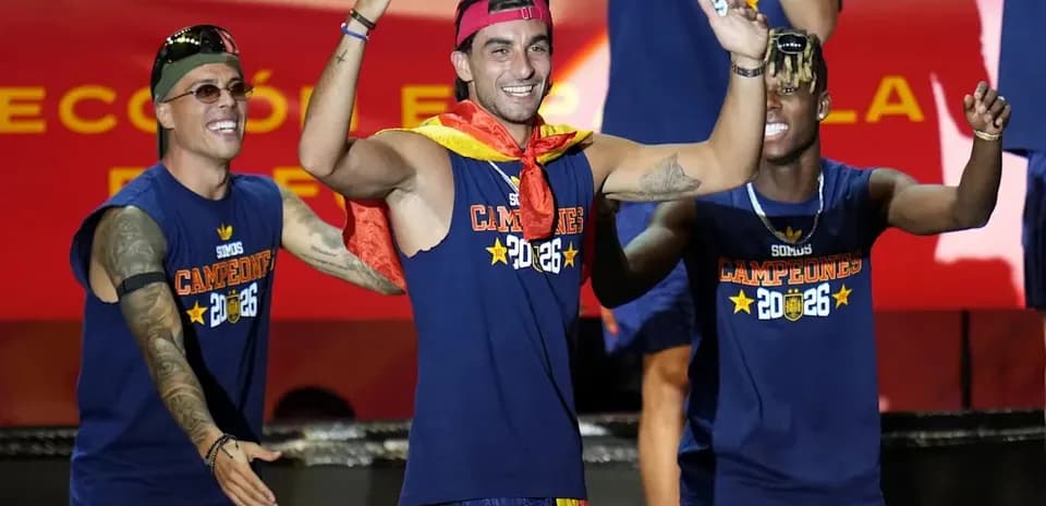 Players celebrating on stage with trophies and flags