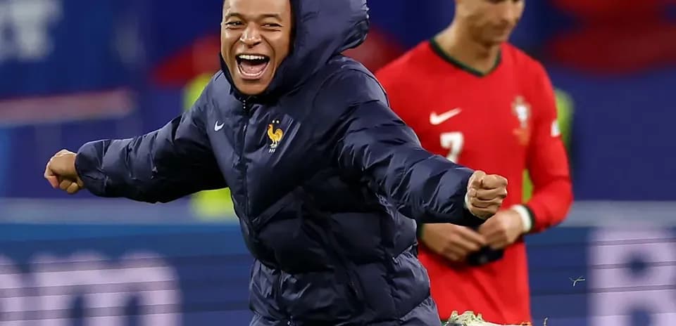 Kylian Mbappé celebrating in France jacket on field