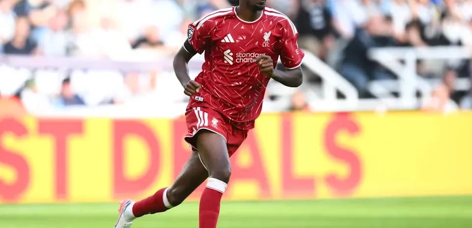 Player in red Liverpool kit running on pitch