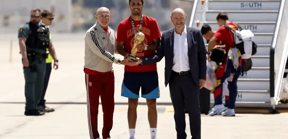 Player receiving trophy at airport arrival ceremony