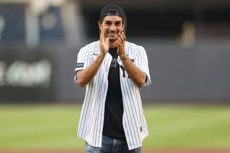 Man in Yankees jersey clapping at baseball field