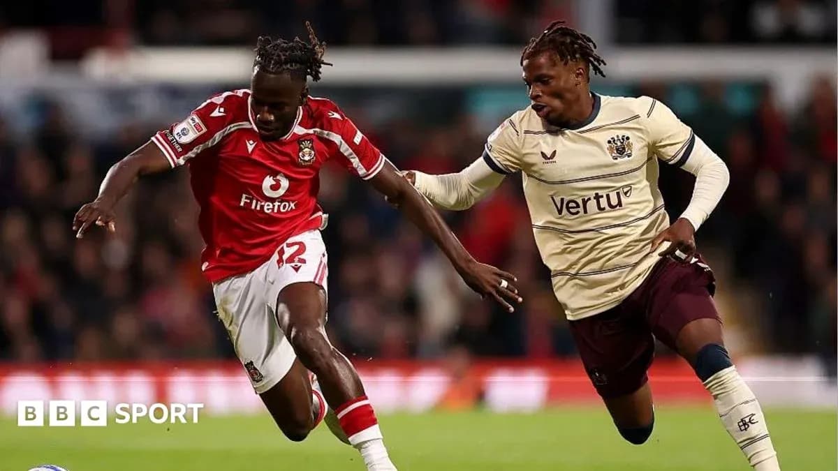 Player in red jersey dribbling past opponent in beige