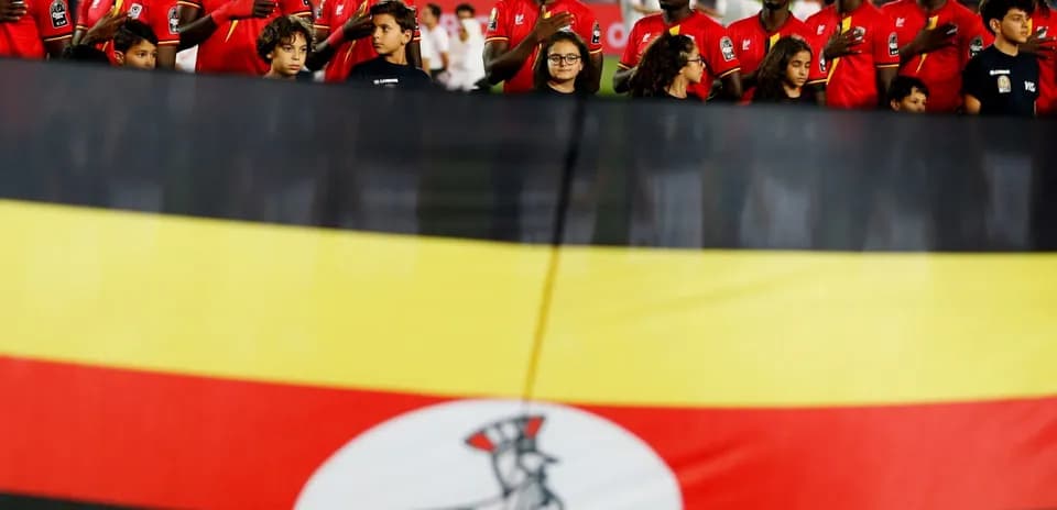 Ugandan team standing for national anthem with flag
