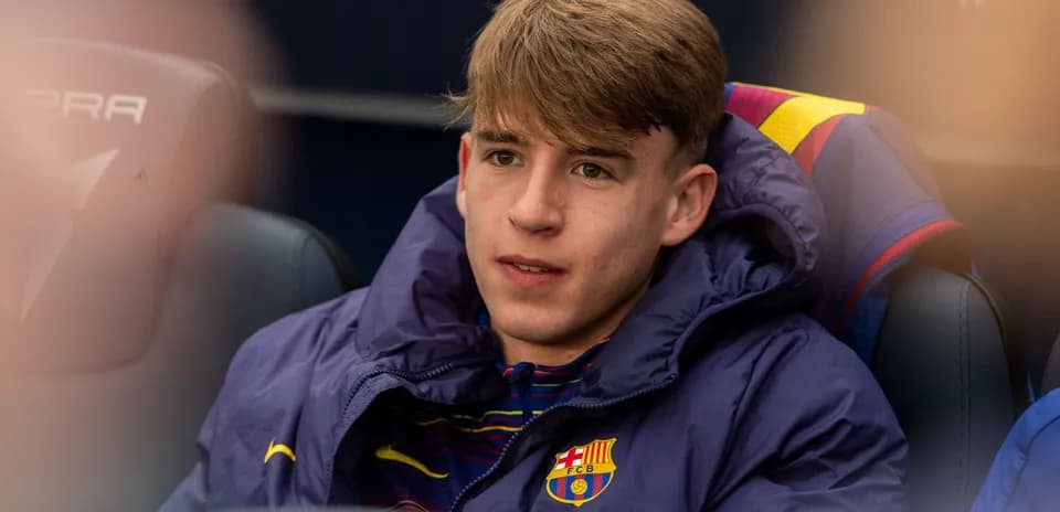 Player seated on bench in Barcelona team jacket