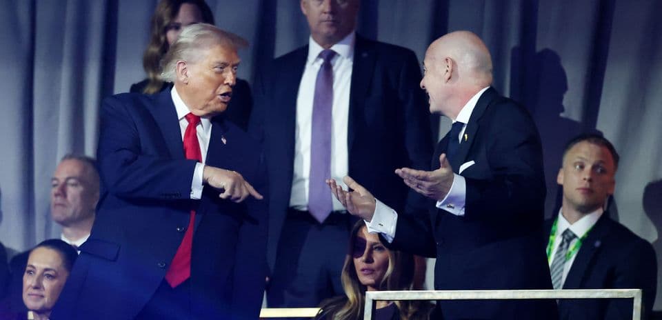 Two men conversing in a crowd at event