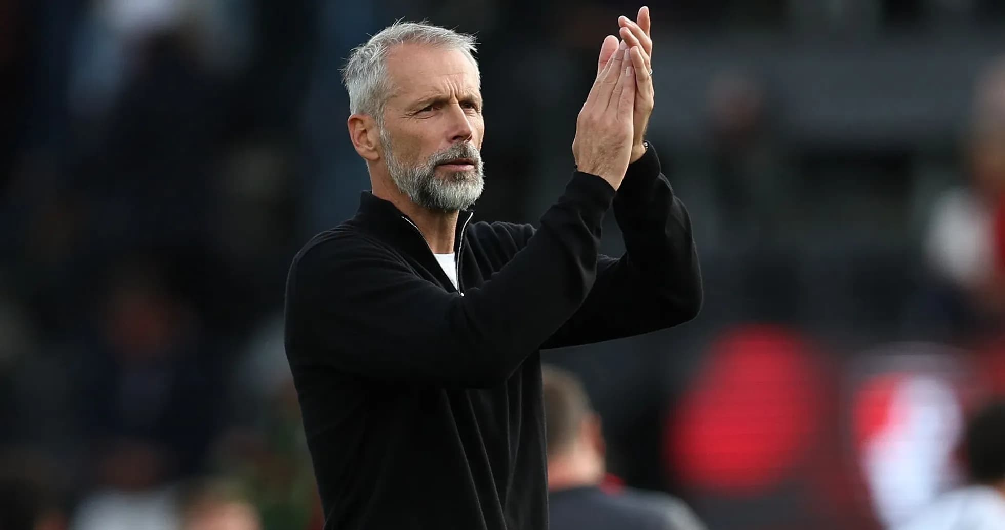 Coach applauding fans during a match