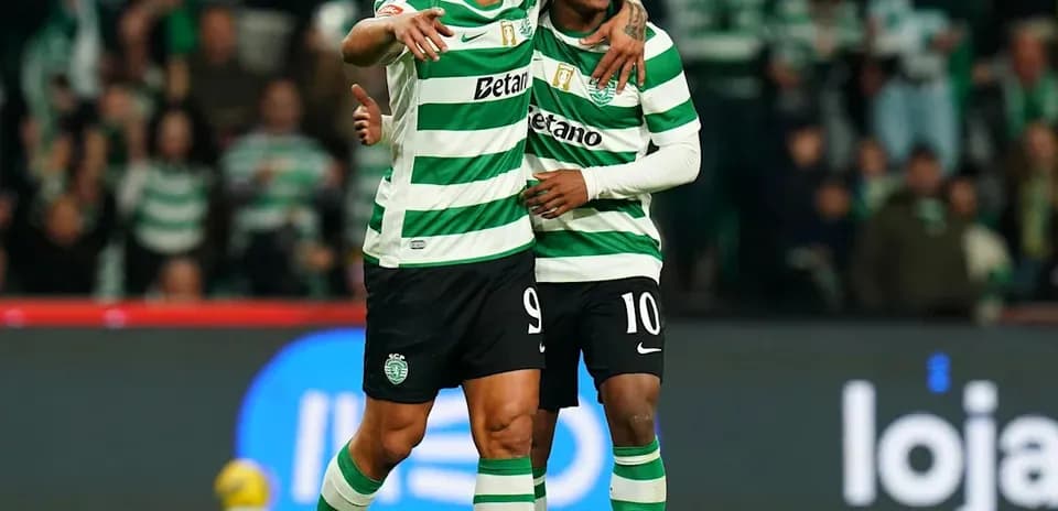 Two players celebrating on the pitch in uniforms