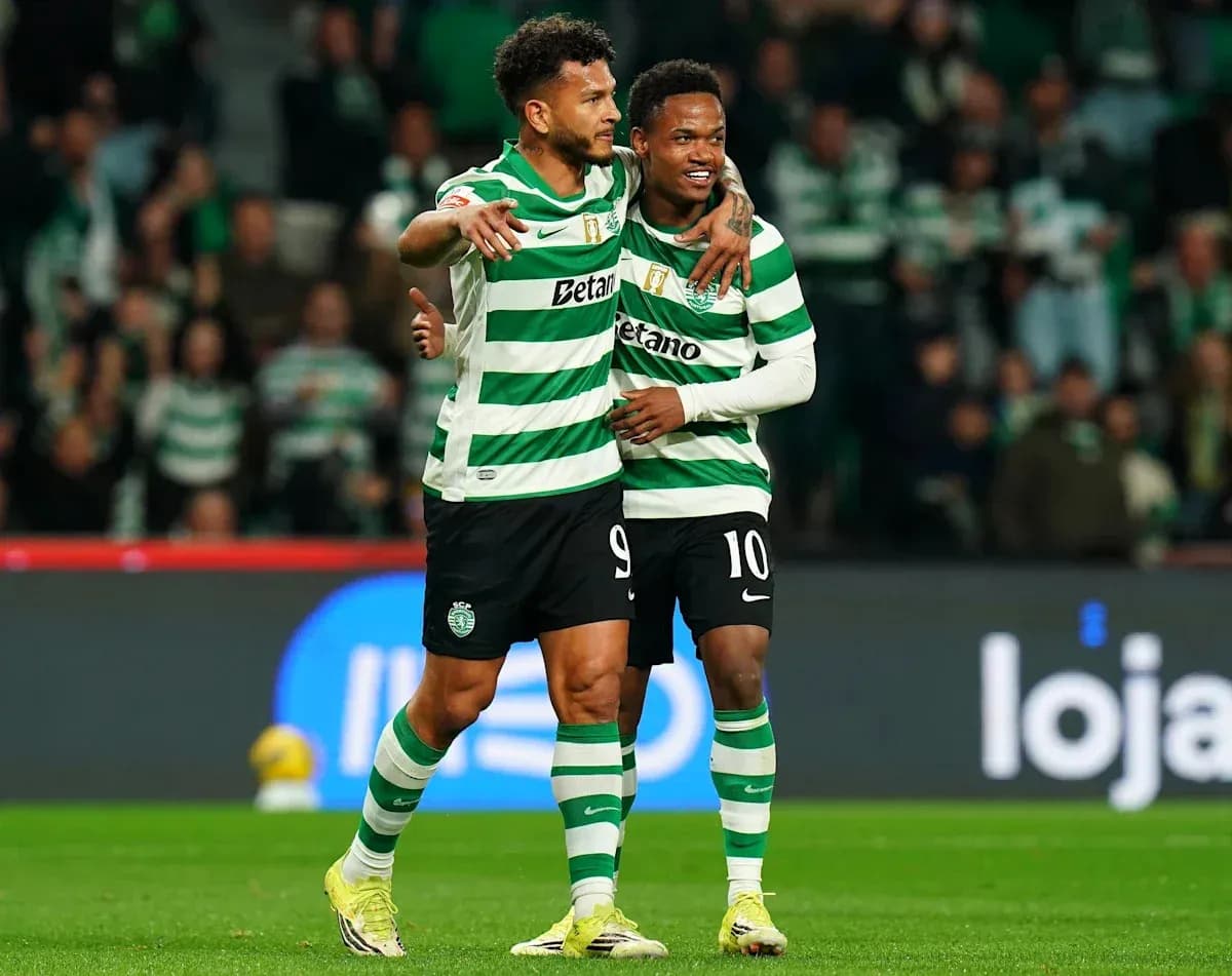 Two players celebrating on the pitch in uniforms