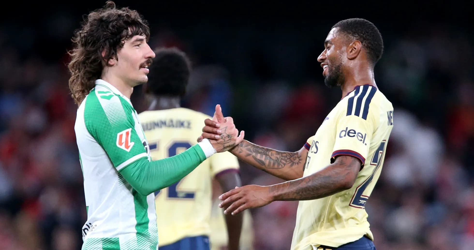 Two football players shaking hands on the pitch