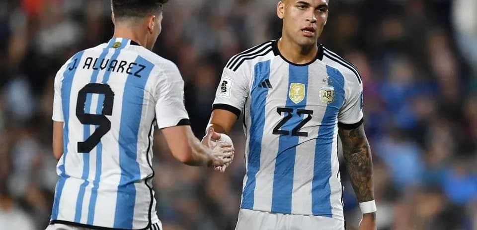 Two Argentina players shaking hands on the pitch