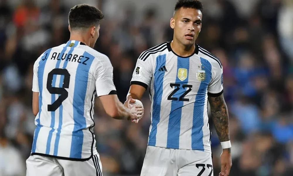Two Argentina players shaking hands on the pitch