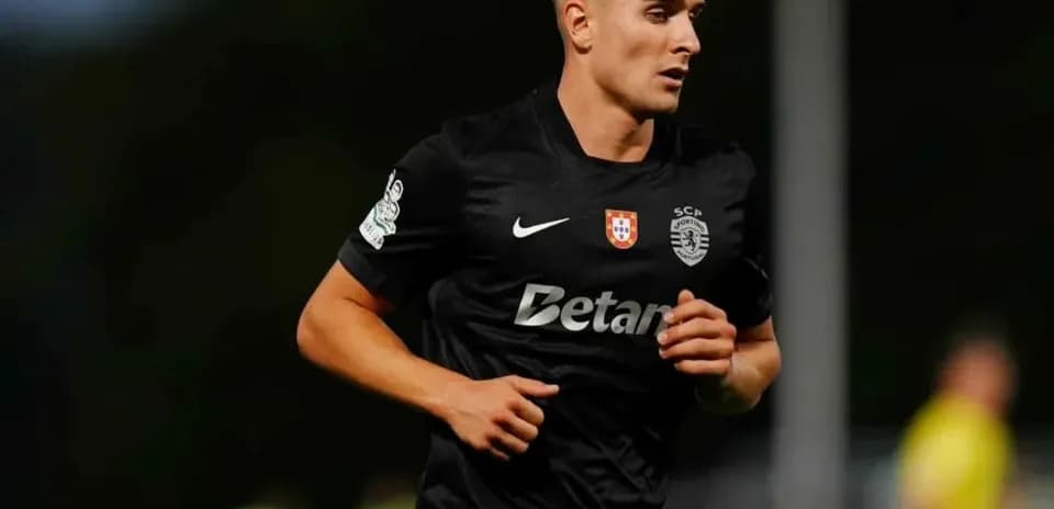 Player running on field in black sports kit
