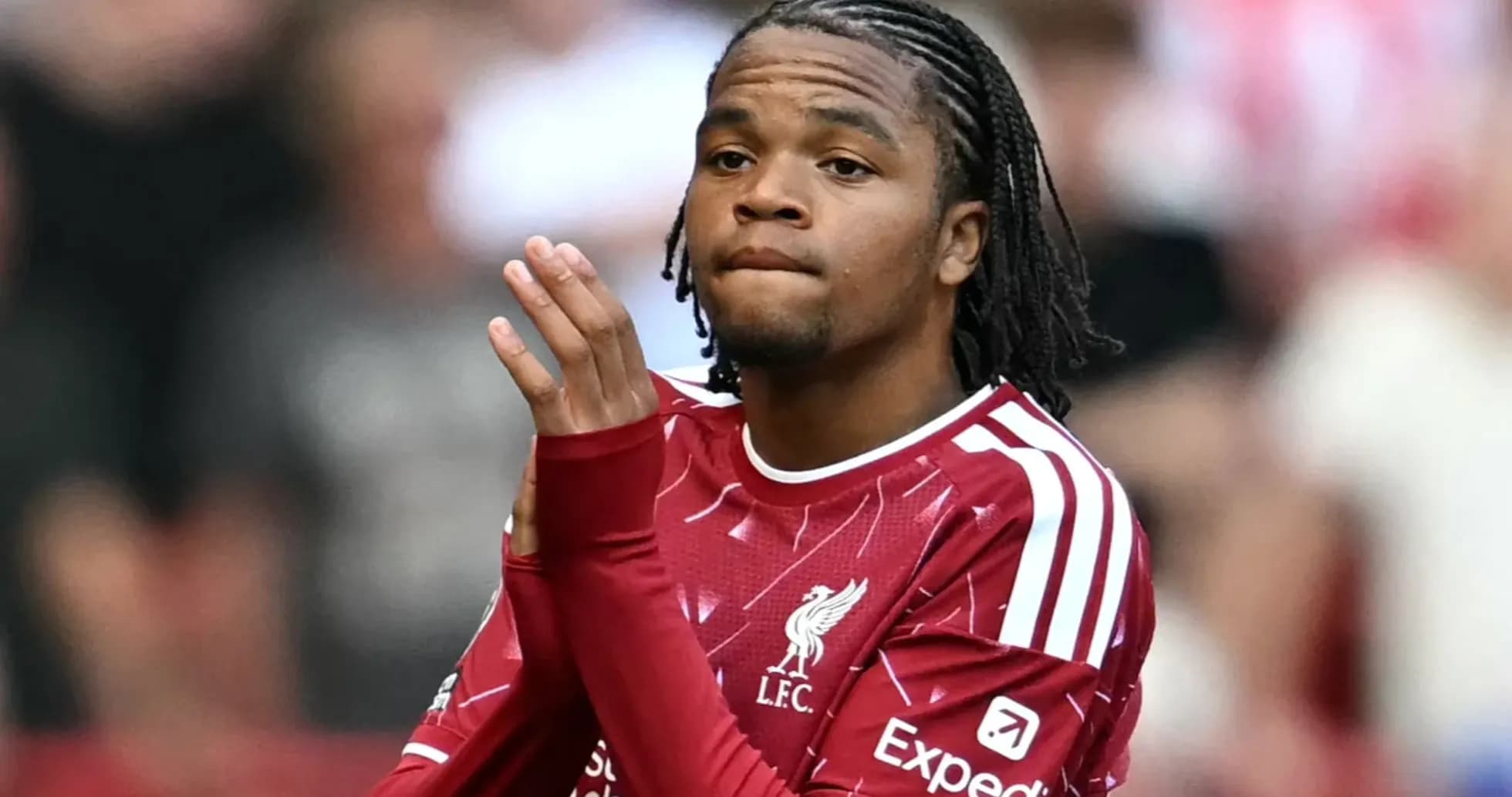 Player in Liverpool kit applauding fans during match