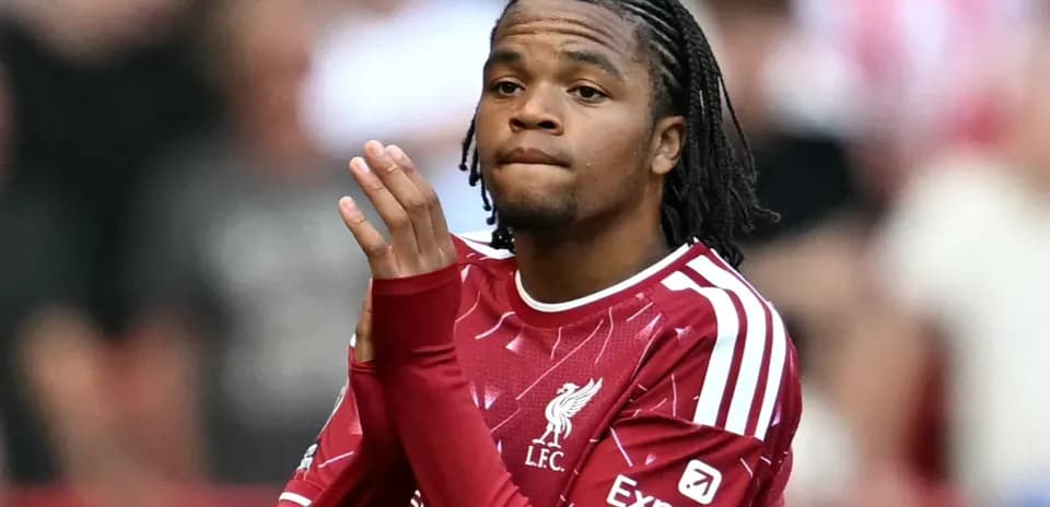 Player in Liverpool kit applauding fans during match