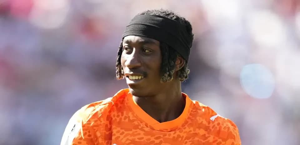 Player in orange jersey during match warm-up