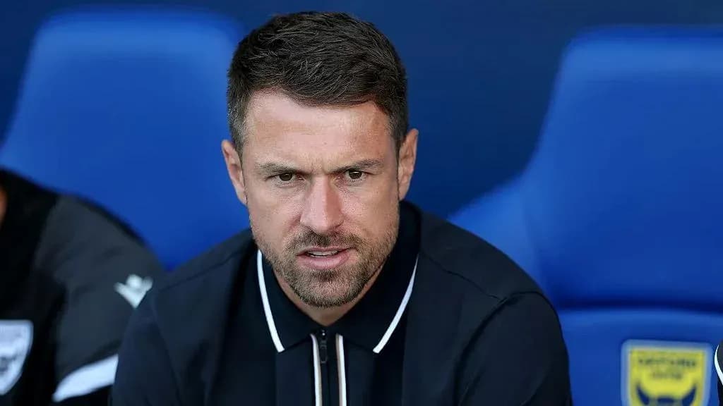 Coach seated on bench during match preparations