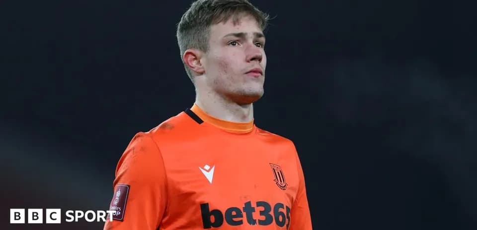 Goalkeeper in orange kit during match preparation