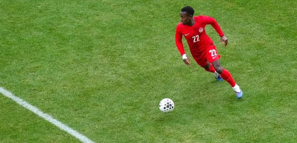 Player in red jersey running with the ball