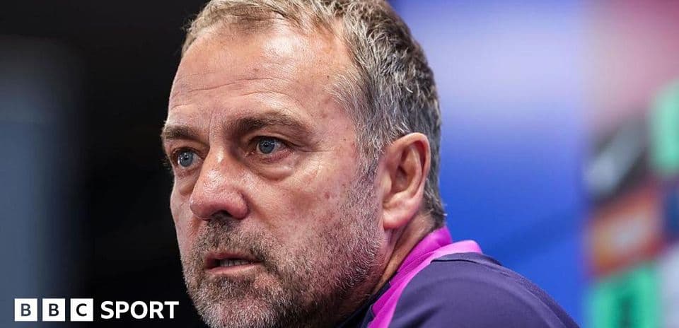 Coach speaking during press conference with serious expression