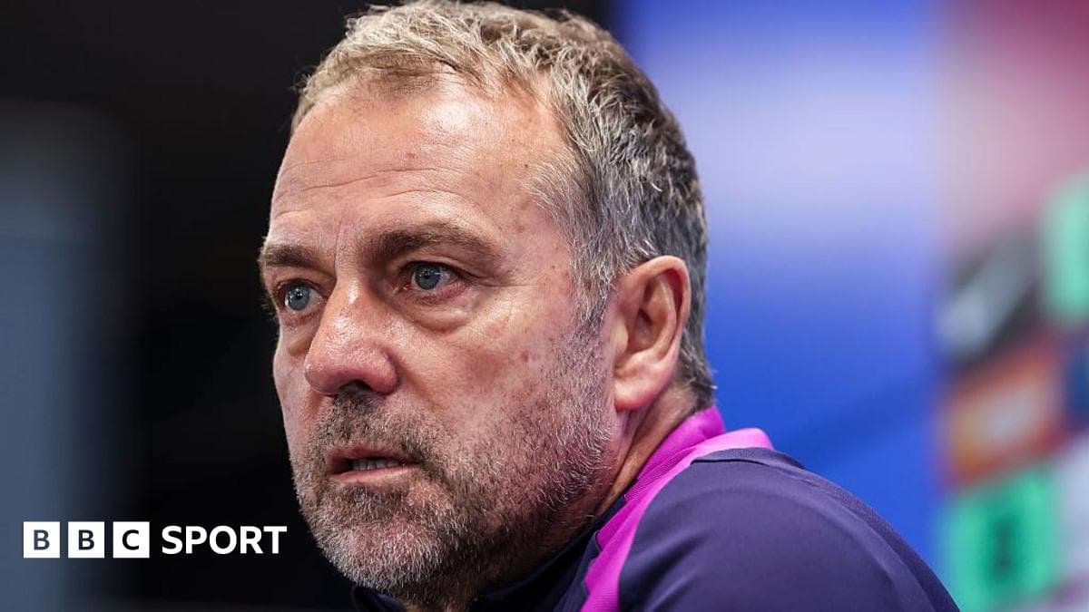 Coach speaking during press conference with serious expression