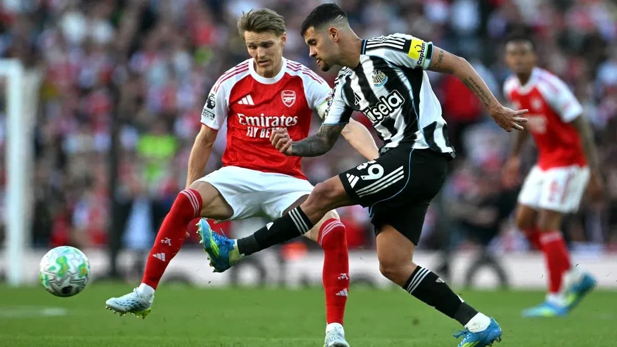 Newcastle player kicking ball past Arsenal opponent