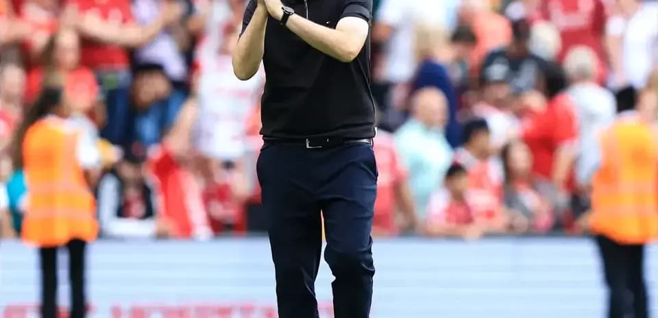 Coach applauding fans on the field after match