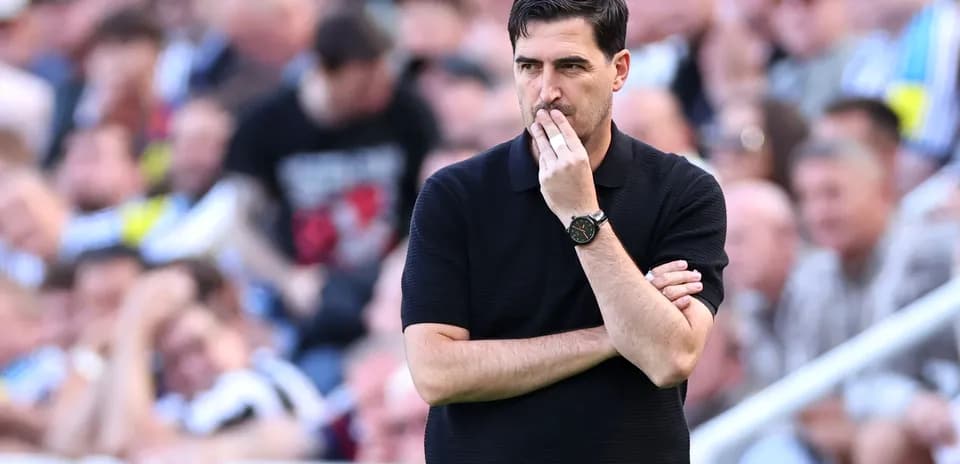 Coach observing match with arms crossed on sideline