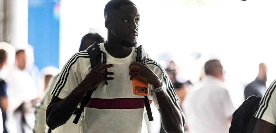 Player arriving at venue holding a phone