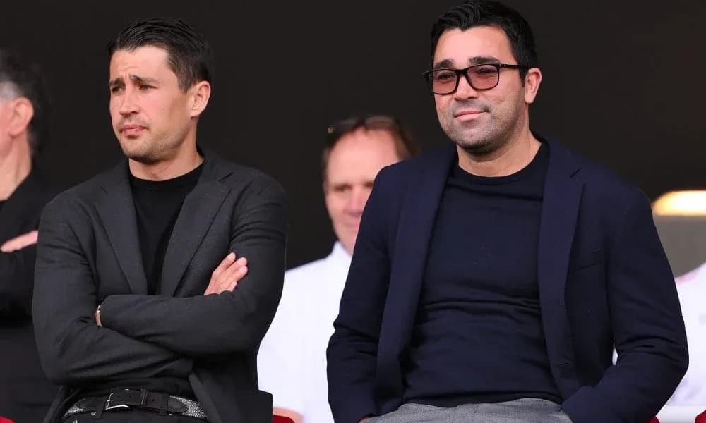 Two men seated in a sports venue viewing event