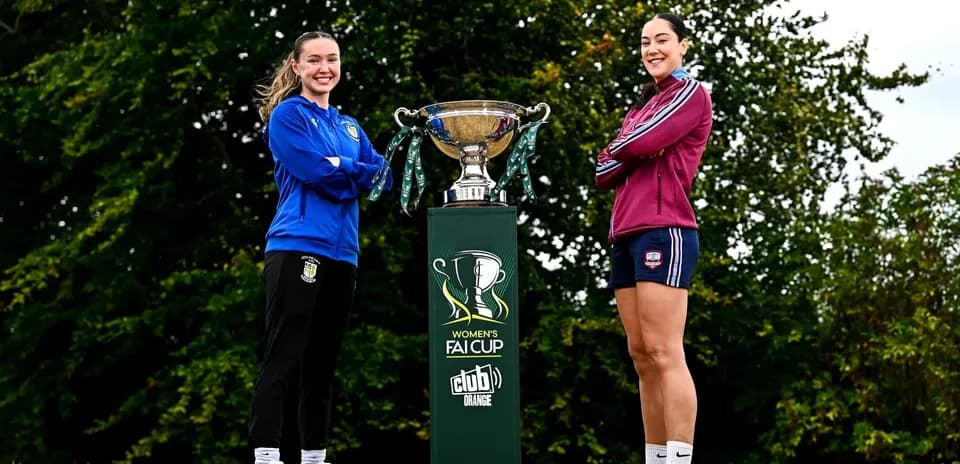 Two players posing with Women's FAI Cup trophy
