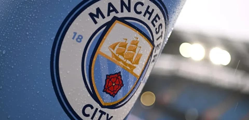 Close-up of Manchester City club badge with raindrops