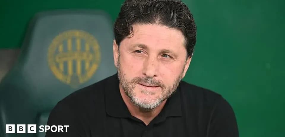 Coach seated on bench during match preparation