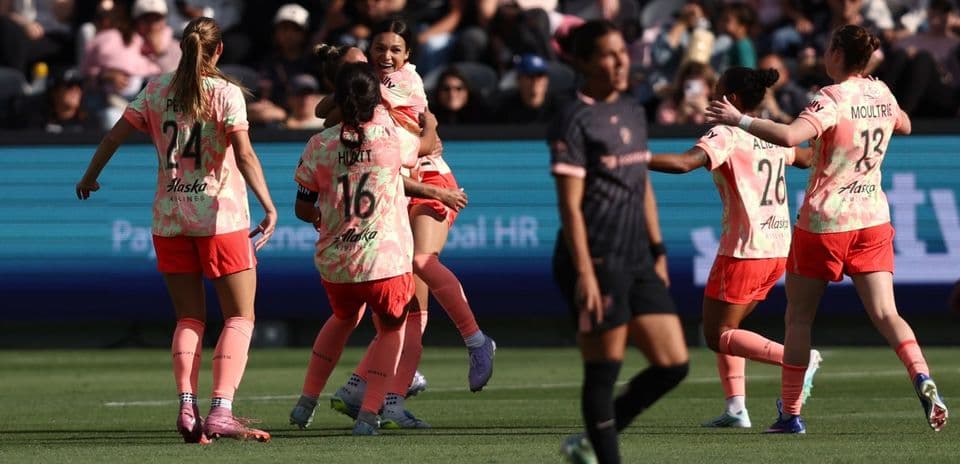 Players celebrating a goal during NWSL match