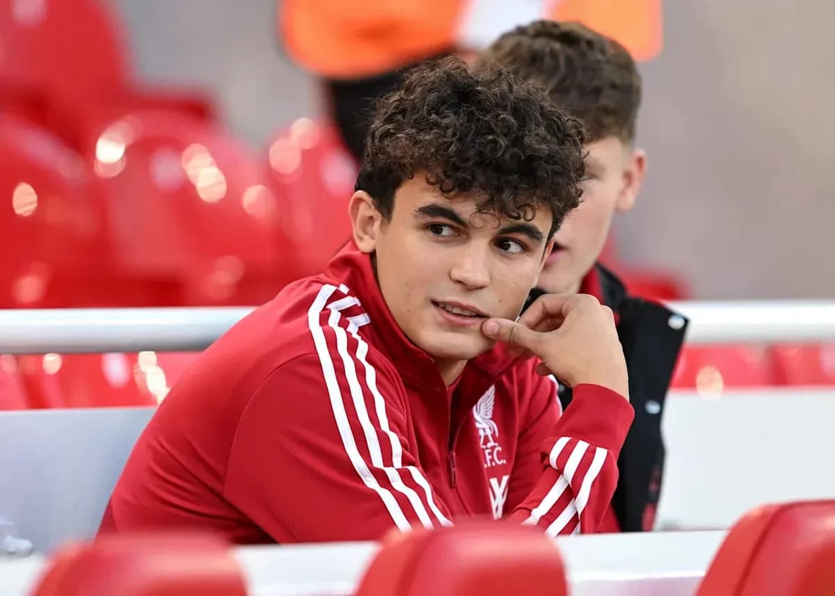 Player in Liverpool FC tracksuit sitting on bench