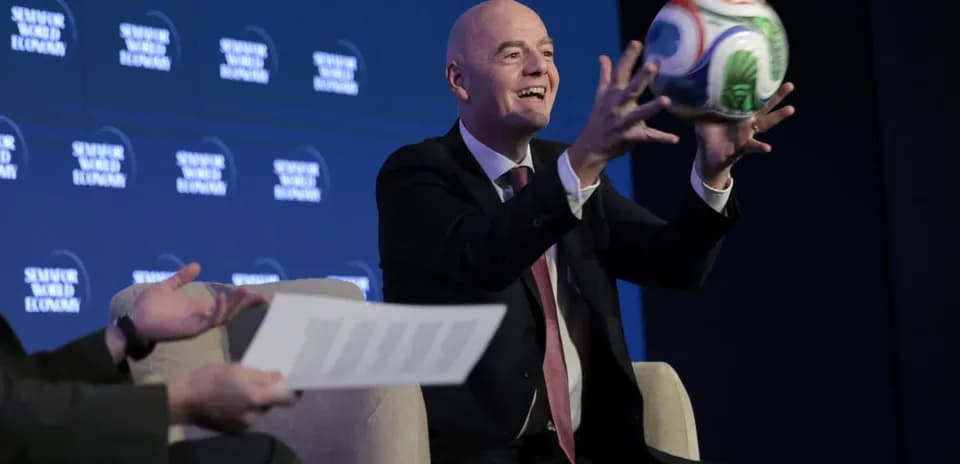 Official holding a soccer ball at press event