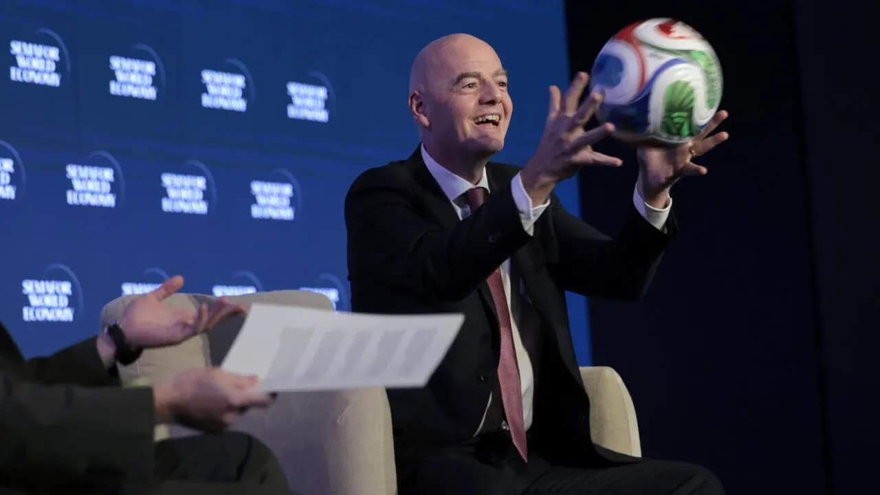 Official holding a soccer ball at press event