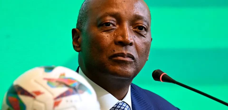 Official at press conference with a football