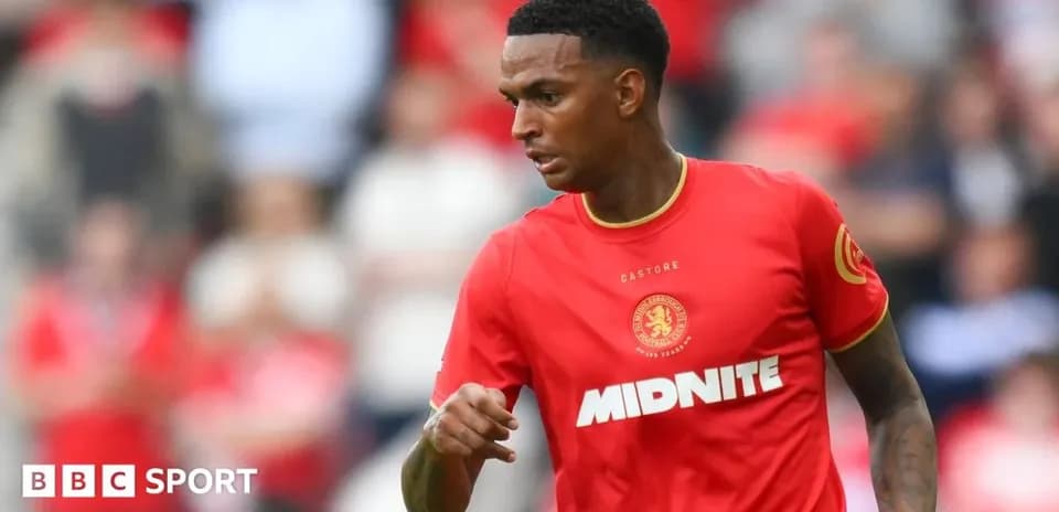 Player in red kit running on the pitch