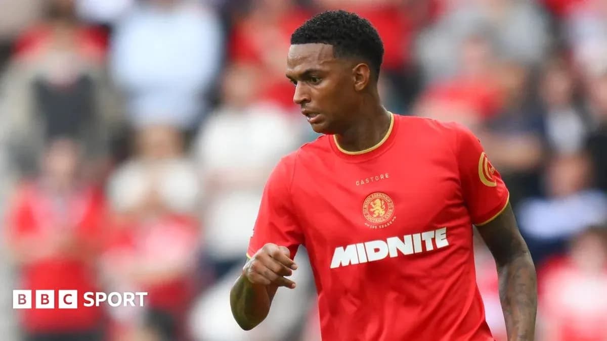 Player in red kit running on the pitch