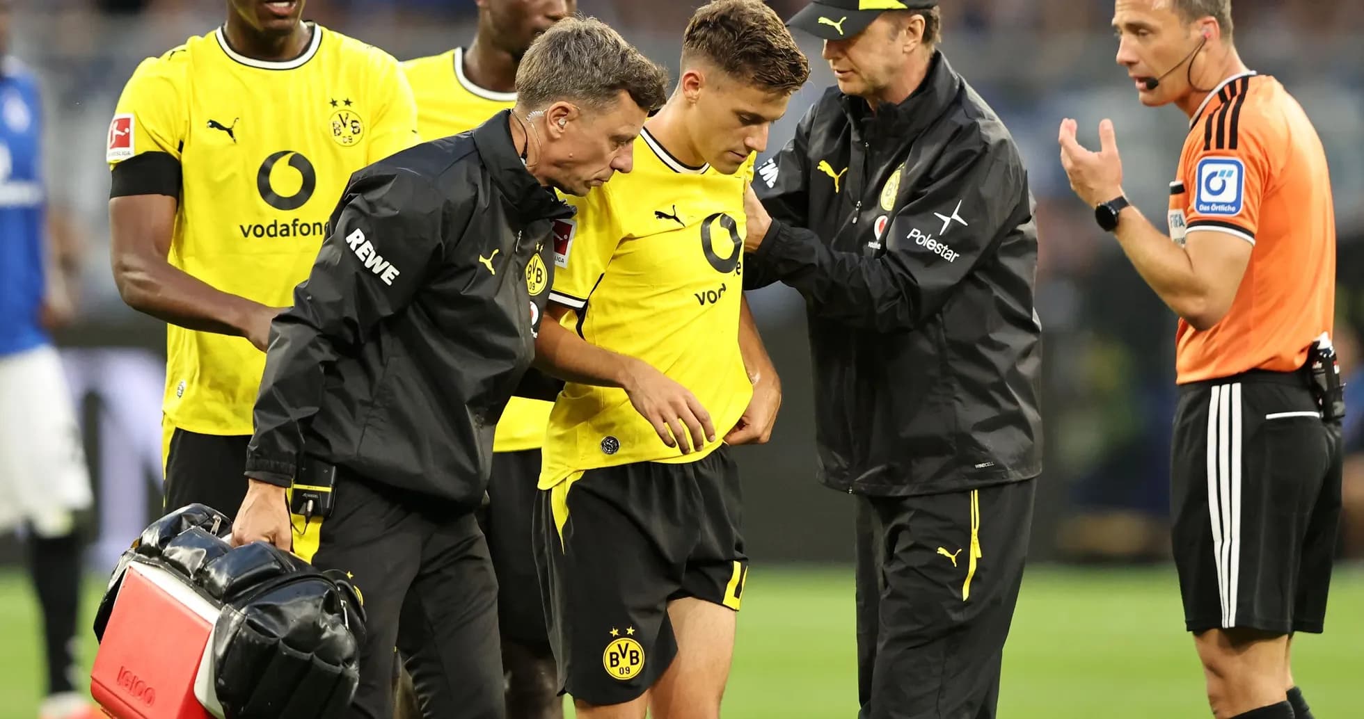 Borussia Dortmund players attending to injured teammate