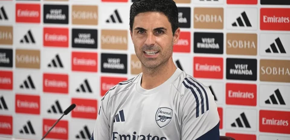 Manager speaking at press conference with Arsenal branding