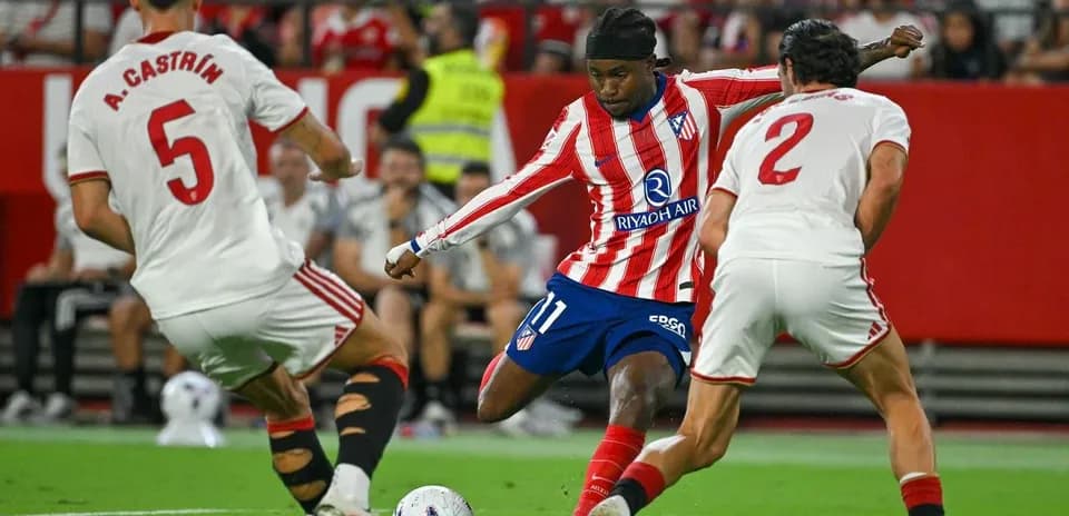 Atletico Madrid player dribbling past Sevilla defenders