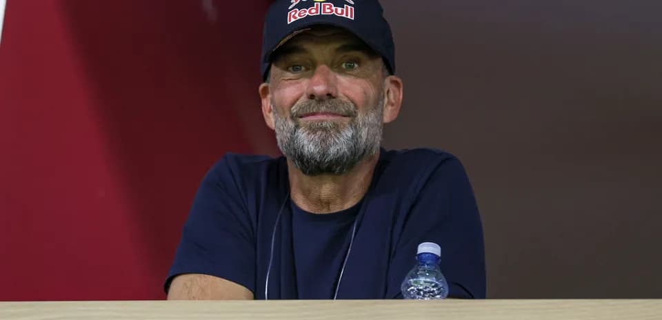 Man with beard wearing Red Bull cap in stands