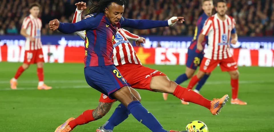 Barcelona player tackling Atletico Madrid opponent