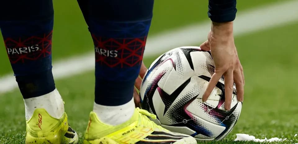 Player placing ball for a set piece on field