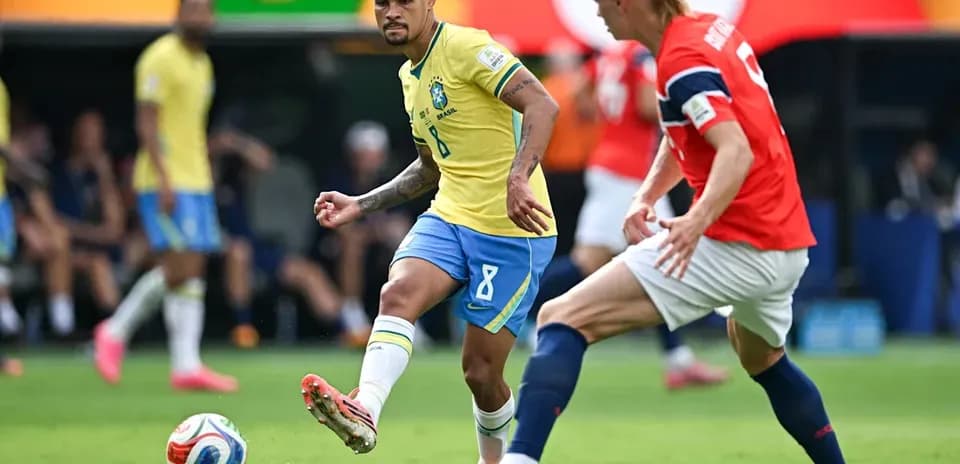 Brazil player dribbling past Norway defender during match