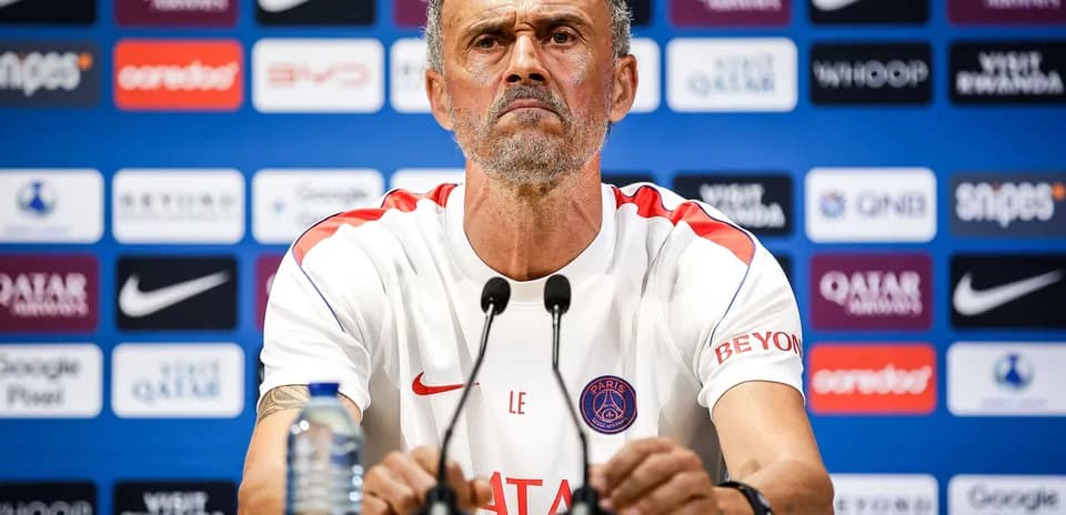 Manager speaking at press conference with team logo